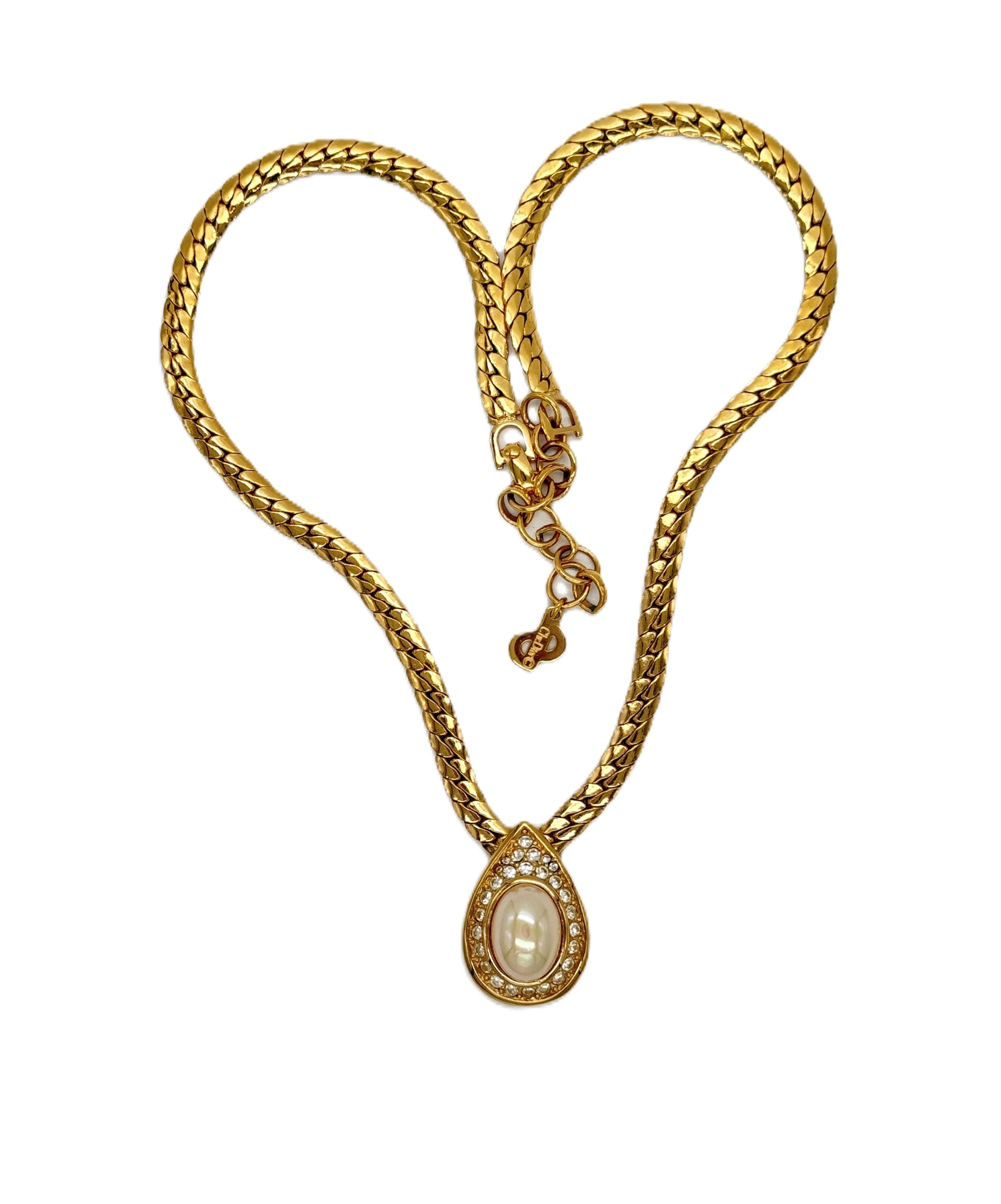 A Christian Dior gold chain necklace with a teardrop-shaped pendant featuring a central white pearl-like stone surrounded by small clear stones.